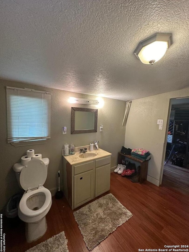 bathroom with vanity, hardwood / wood-style flooring, toilet, and a textured ceiling