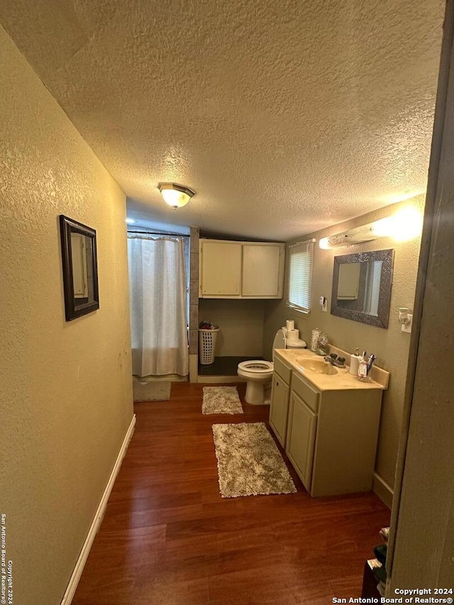 kitchen with sink, cream cabinets, dark hardwood / wood-style flooring, and a textured ceiling