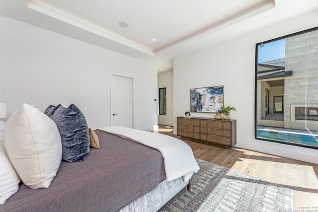 bedroom with dark wood-type flooring and a tray ceiling