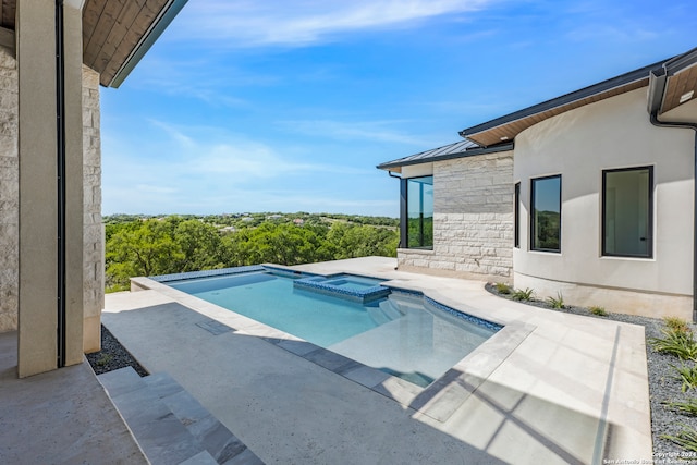 view of swimming pool featuring a patio area and an in ground hot tub