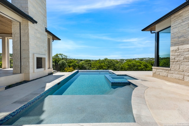 view of pool with an in ground hot tub and a patio