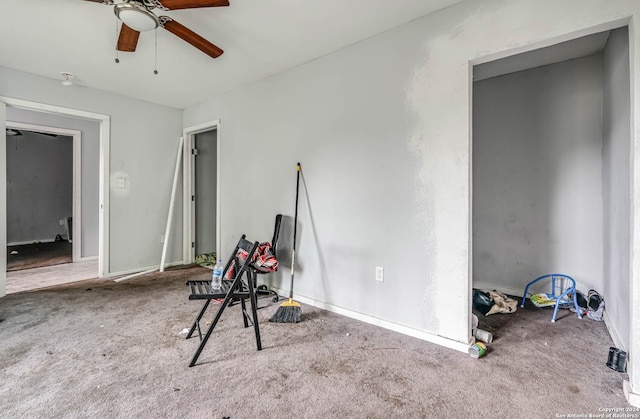 interior space featuring ceiling fan and carpet