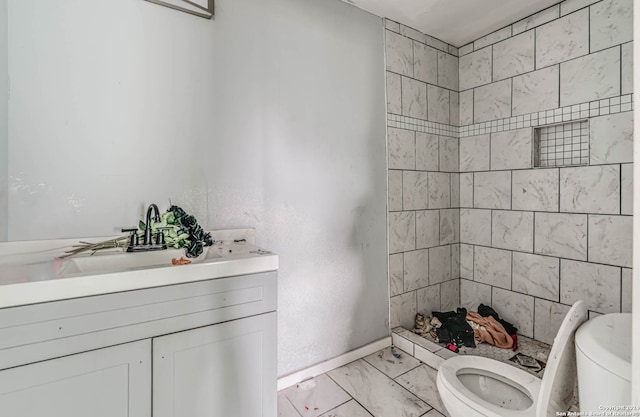 bathroom with tiled shower, toilet, tile flooring, and vanity