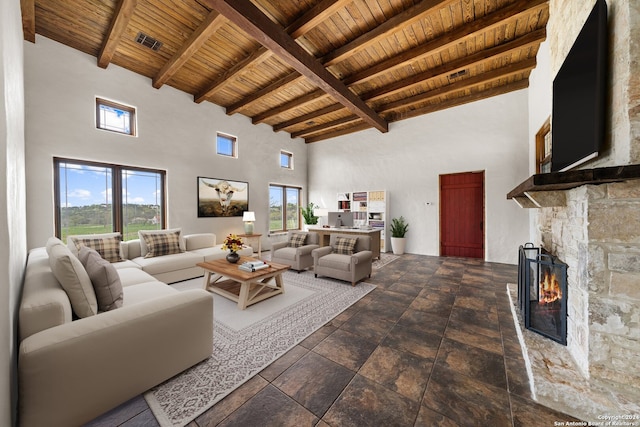 living room featuring wood ceiling, dark tile flooring, a towering ceiling, and a fireplace