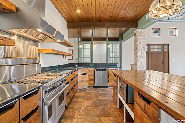 kitchen featuring beamed ceiling, dark tile floors, wall chimney exhaust hood, stainless steel appliances, and wooden ceiling