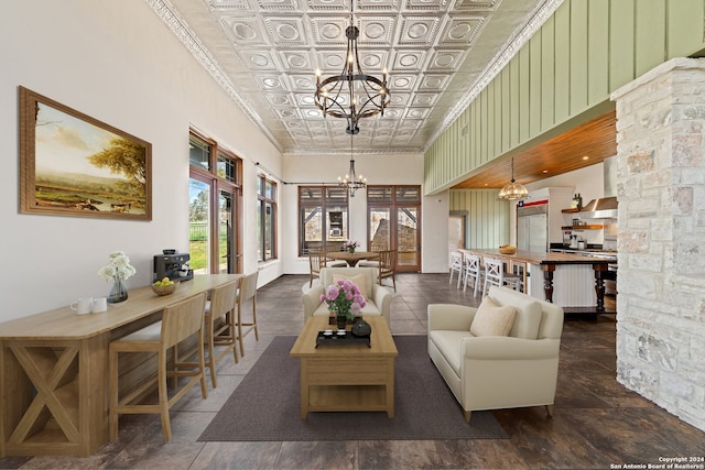 tiled living room with ornamental molding, a notable chandelier, and a high ceiling