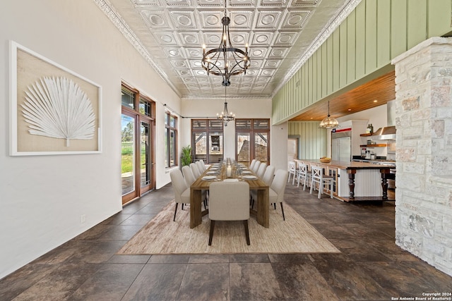 dining room with dark tile flooring, a towering ceiling, and a notable chandelier