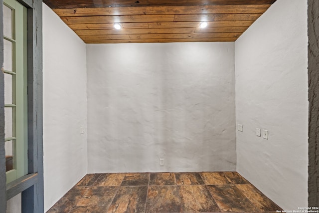 tiled spare room featuring wooden ceiling