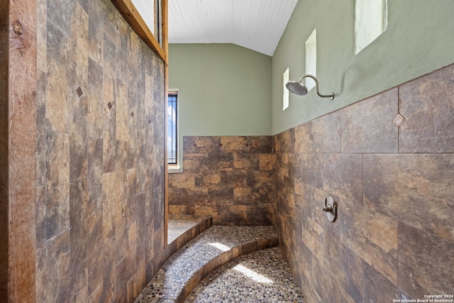 bathroom featuring tile walls and vaulted ceiling