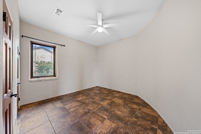 tiled empty room featuring ceiling fan