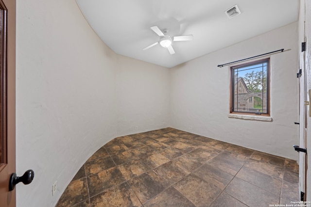 spare room featuring dark tile floors and ceiling fan