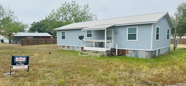 rear view of property featuring a lawn