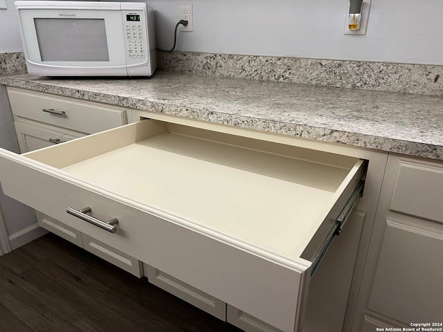 room details featuring white cabinets and dark wood-type flooring