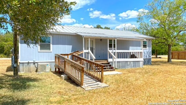 view of front facade featuring a front yard and central AC