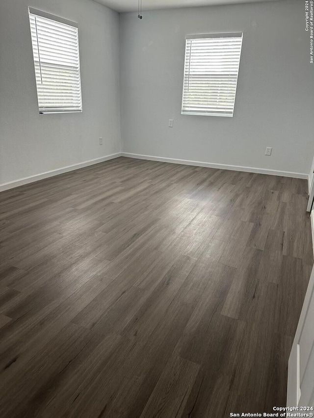 spare room with ceiling fan and dark hardwood / wood-style flooring