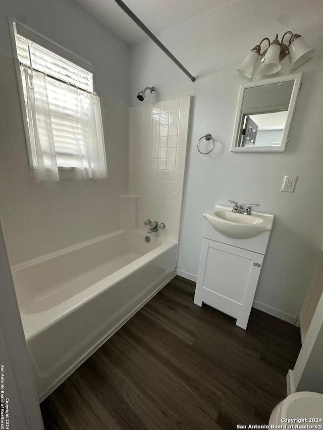 bathroom featuring vanity, wood-type flooring, and tiled shower / bath