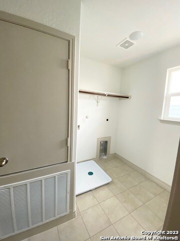 laundry area featuring light tile floors