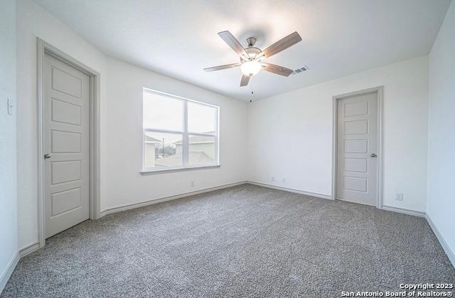 spare room featuring ceiling fan and light carpet