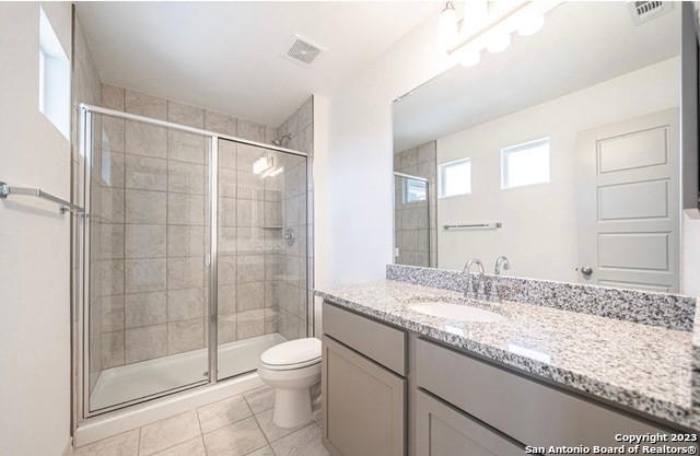 bathroom featuring oversized vanity, an enclosed shower, tile floors, and toilet