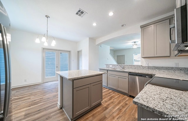 kitchen featuring light hardwood / wood-style flooring, a center island, gray cabinetry, and appliances with stainless steel finishes