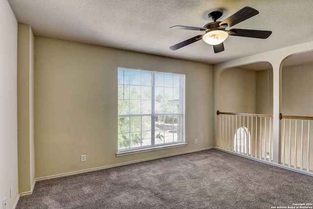 carpeted spare room featuring ceiling fan and a textured ceiling