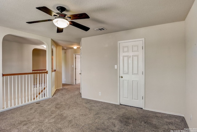 unfurnished room featuring light carpet, ceiling fan, and a textured ceiling