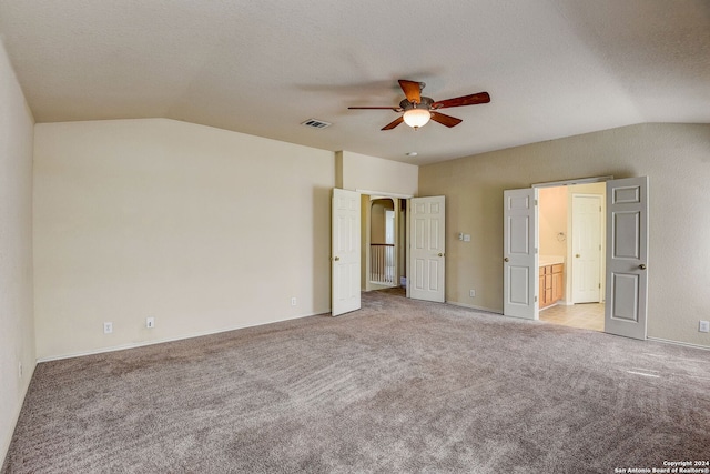 carpeted empty room featuring vaulted ceiling and ceiling fan