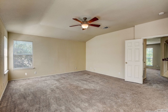 unfurnished room with lofted ceiling, ceiling fan, and dark carpet