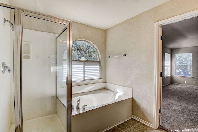 bathroom with a wealth of natural light, tile flooring, and plus walk in shower