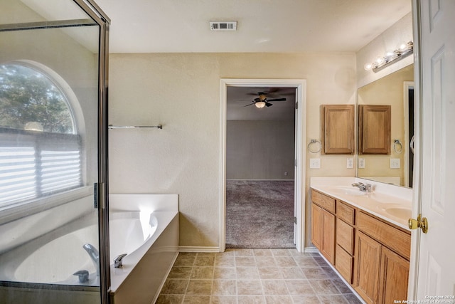 bathroom featuring a healthy amount of sunlight, vanity with extensive cabinet space, a bath, and tile flooring