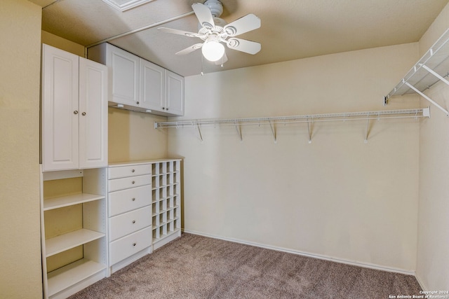 spacious closet with light carpet and ceiling fan