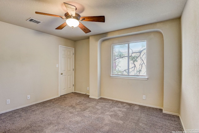 carpeted spare room with ceiling fan and a textured ceiling