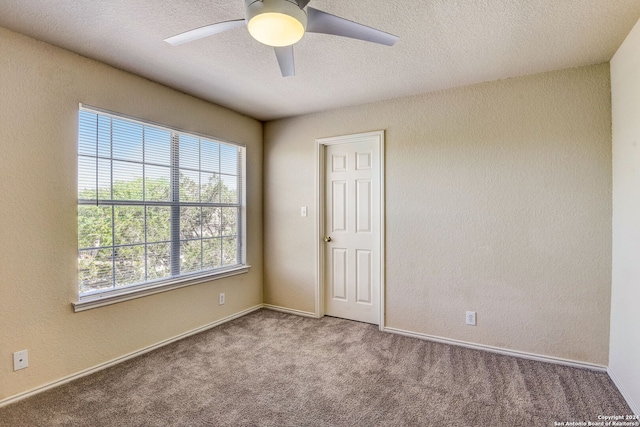 carpeted spare room with a textured ceiling and ceiling fan