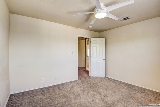 carpeted spare room featuring ceiling fan