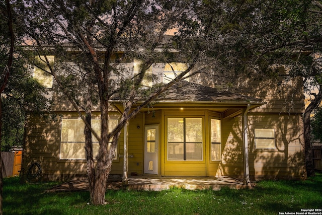 exterior entry at dusk with a lawn