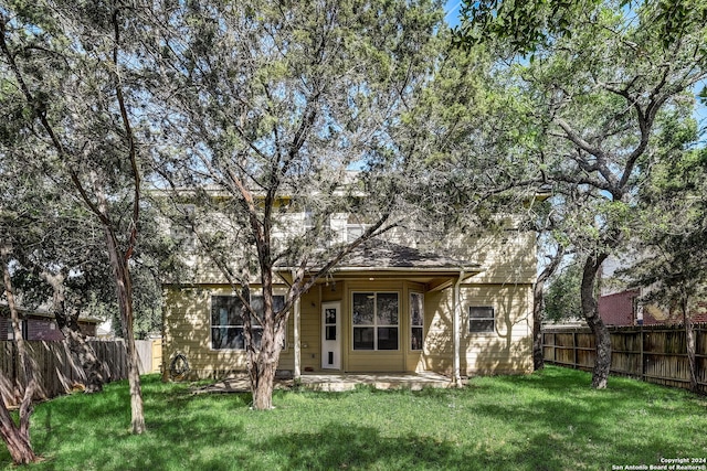 rear view of property with a yard