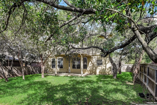 back of house featuring a lawn