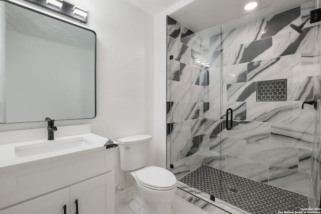 bathroom featuring vanity with extensive cabinet space, an enclosed shower, and toilet