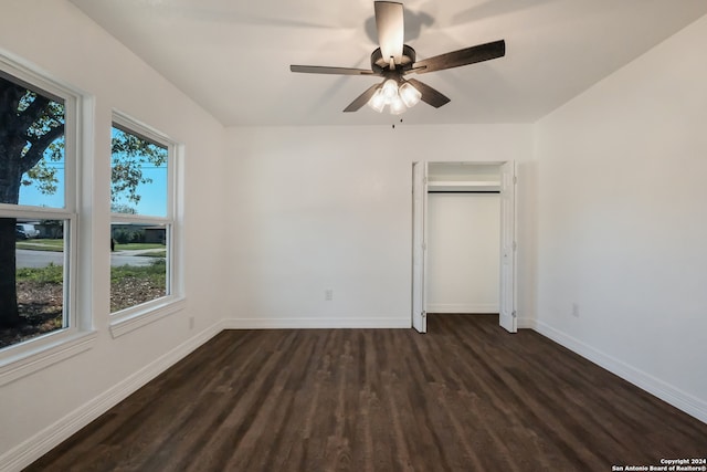 unfurnished bedroom with ceiling fan and dark wood-type flooring