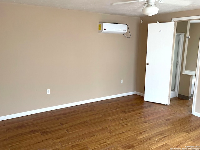 interior space featuring a wall unit AC, ceiling fan, a textured ceiling, and hardwood / wood-style flooring