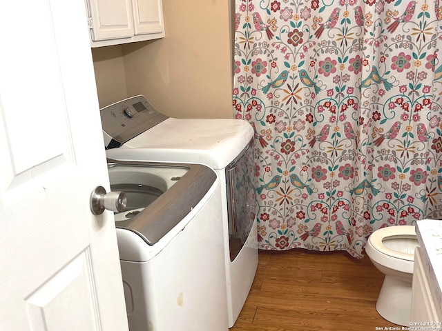 laundry area featuring washer and clothes dryer and dark hardwood / wood-style flooring