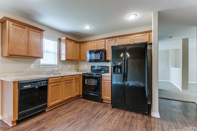 kitchen featuring sink, black appliances, and dark hardwood / wood-style floors