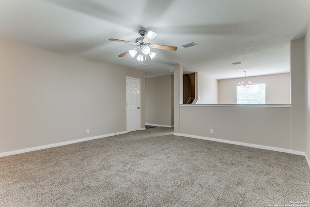 spare room featuring ceiling fan with notable chandelier and light carpet