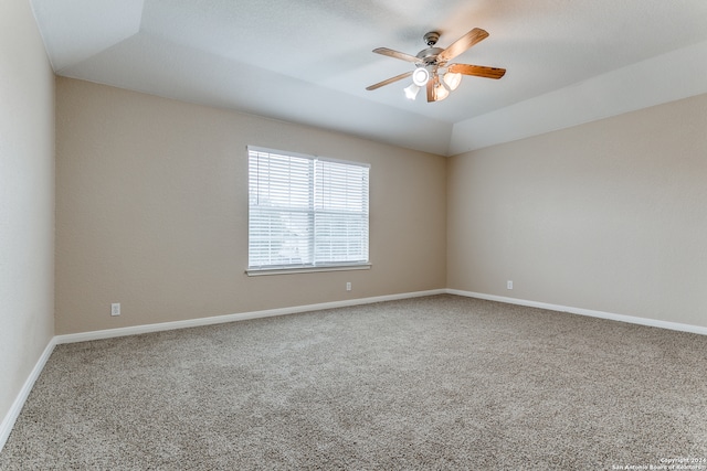 carpeted spare room featuring vaulted ceiling and ceiling fan