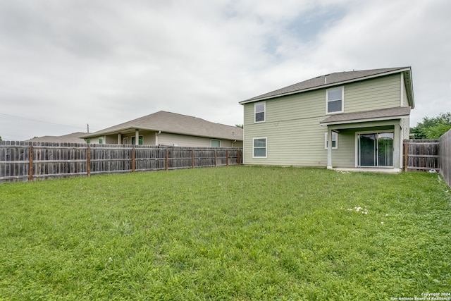 rear view of property with a lawn