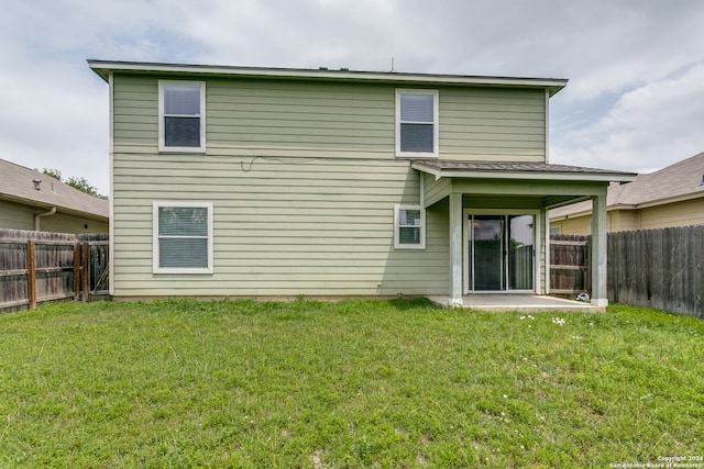 rear view of house featuring a yard