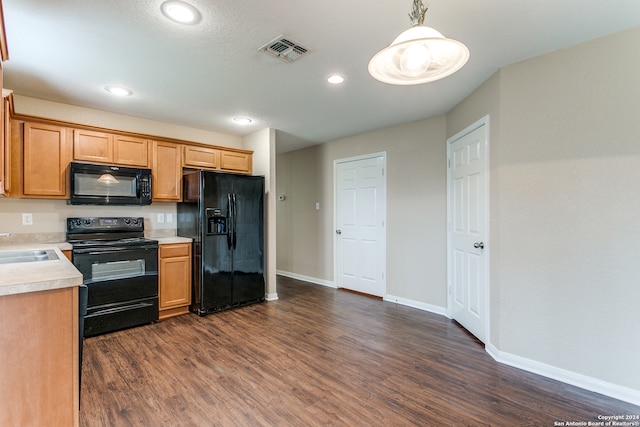 kitchen featuring dark hardwood / wood-style floors, sink, decorative light fixtures, and black appliances