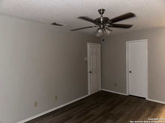 unfurnished room with a textured ceiling, ceiling fan, and dark wood-type flooring