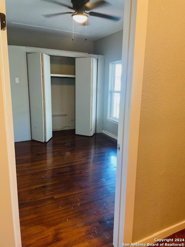 unfurnished bedroom with dark wood-type flooring and ceiling fan