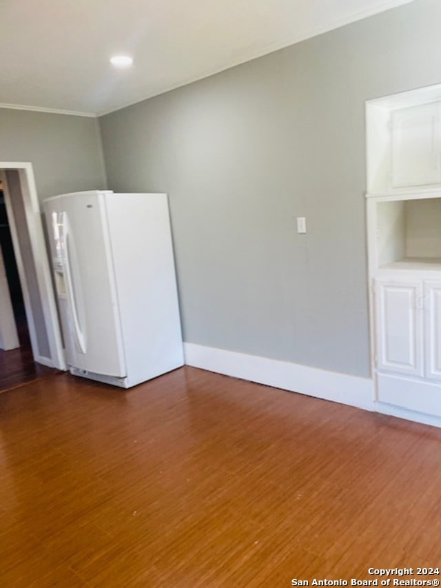 unfurnished room featuring crown molding and hardwood / wood-style floors